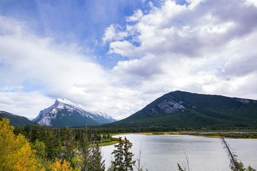 river in the middle of the forests and peaks of the rocky mountains of alberta canada