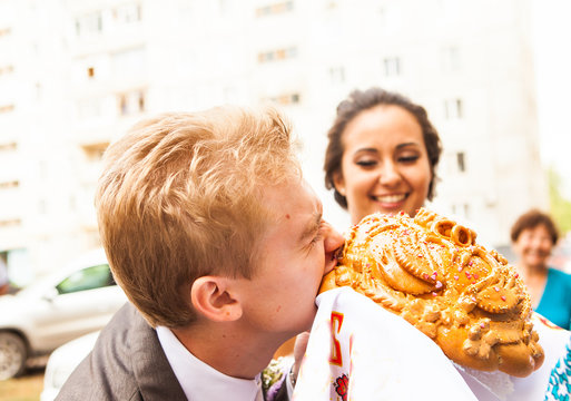 Closeup photo of bride and groom nibbling traditional loaf