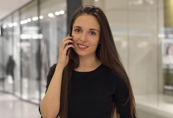 Closeup of a beautiful smiling woman using mobile phone