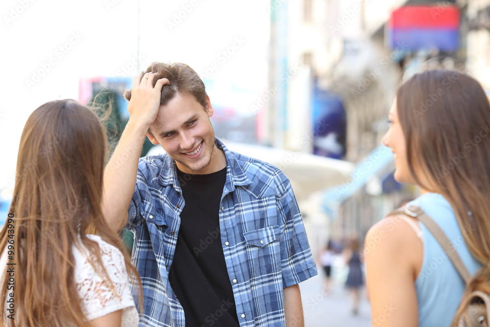 Wall mural young man flirting with two girls