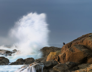 Mutiger Fotograf an der Felsenüste von Pendruc in der Bretagne fotografiert Brecher