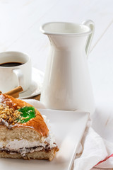 close up of ring-shaped cake with icing sugar, cream, mint, cinn