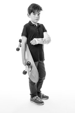 cute young boy holding a skateboard