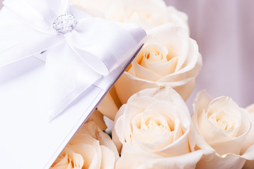 The wedding invitation with wedding rings and a bouquet of the bride on a white background