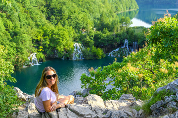 Plitvice Lakes with beustiful woman laying on the rocks