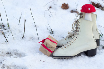 Ice skates and gift on snow