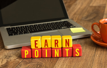 Earn Points written on a wooden cube in a office desk
