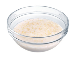 Oatmeal in a glass bowl on white background
