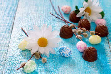 Colorful Easter eggs, spring flowers and chocolates