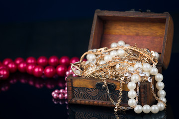 Chest with jewels on dark background