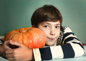 Fototapeta premium boy with big orange pumpkin close up portrait