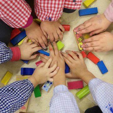 Manos de niños jugando con madera de colores