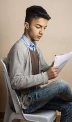 Iraqi boy in student style with white paper and red pen