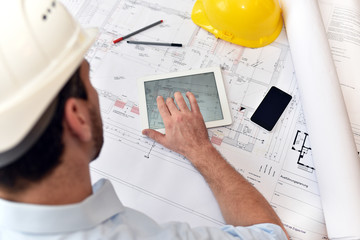 Planung und Entwicklung im Bauwesen - Architekt mit Tablet und techn. Zeichnung am Arbeitsplatz - obrazy, fototapety, plakaty