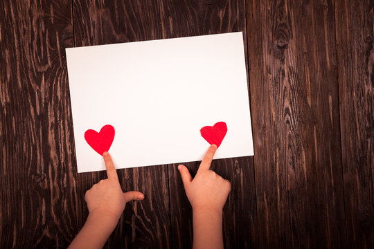 white sheet of paper little red hearts  wooden background