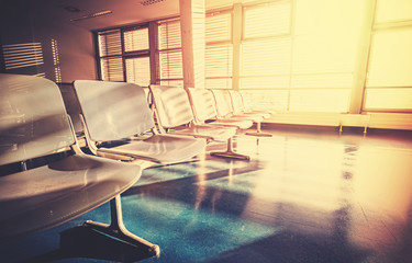 Vintage gefiltertes Bild des leeren Flughafenwartezimmers bei Sonnenaufgang.