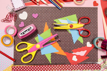 Arts and craft supplies for Saint Valentine's. Color paper, pencils, different washi tapes, craft scissors, hearts supplies for decoration.