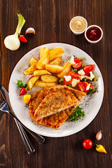 Fried pork chop, baked potatoes and vegetable salad 