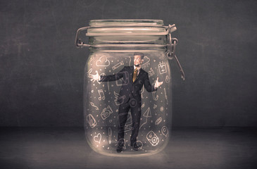 Business man captured in glass jar with hand drawn media icons c