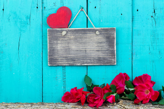 Blank sign and red roses by wood background