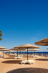 sun loungers and a beach umbrella on a beach perfect vacation concept