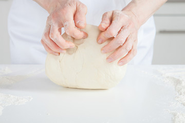 Unrecognizable female cook kneading dough