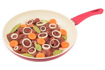 fresh chicken liver with carrot and onion slices, bay leaves and allspice in a white frying pan
