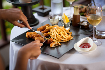 woman’s hands cutting  grilled meat white plate
