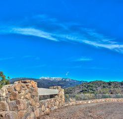 Snowy peak of Topa Topa over Ojai with stonework in foreground.