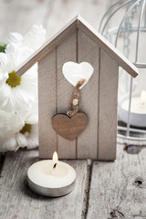 Easter background with candle, flowers and birdhouse