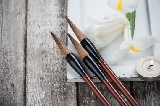 Candle, irisis and Chinese writing brush pens