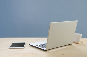 Office desk with notepad, notebook and coffee cup . View from fr