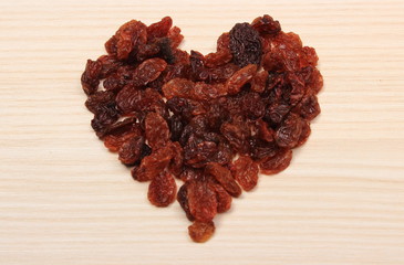 Heart of raisins on wooden table, healthy eating and symbol of love