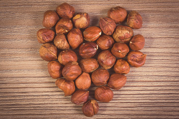 Vintage photo, Heart of brown hazelnut on wooden table