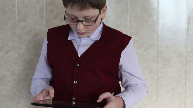 child plays on the plate standing against the wall