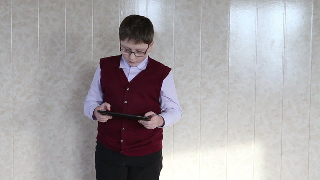 child plays on the plate standing against the wall
