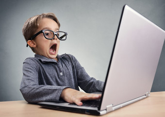 Shocked and surprised boy on the internet with laptop computer - obrazy, fototapety, plakaty