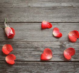 rose and petal in form heart on wooden background