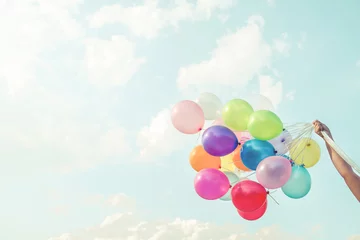 Fotobehang Ballon Girl hand holding multicolored balloons done with a retro vintage instagram filter effect, concept of happy birthday in summer and wedding honeymoon party (Vintage color tone)