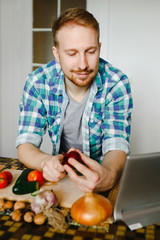Fototapeta premium Young man cooking in home kitchen