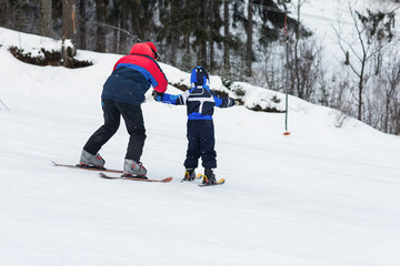 Female instructors teach a child skiing on winter resort