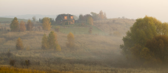 Dom wiejski w jesiennej mglistej scenerii