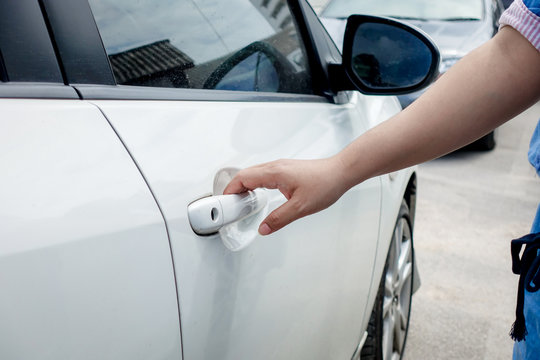 woman hand holding door car to unlock or lock the white car