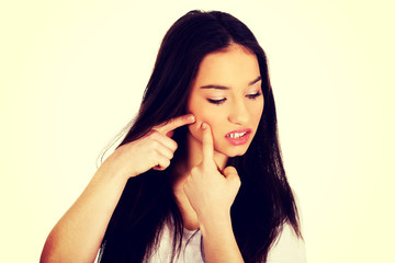 Fototapeta premium Teenage woman squeezing pimple.