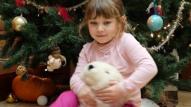 enfant au pied du sapin jouant avec ses cadreaux