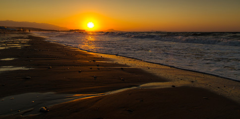 Fototapeta na wymiar A beautiful beach on a Greek island in summer, under warm sunset light