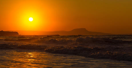 Obraz premium A beautiful beach on a Greek island in summer, under warm sunset light
