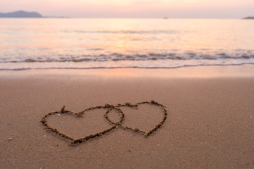 two hearts drawn in beach