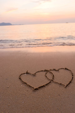 two hearts drawn in beach