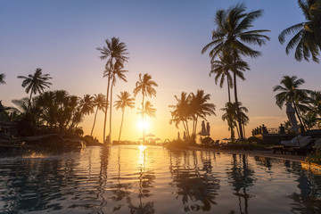 Luxury hotel, palm trees, swimming pool, sunset